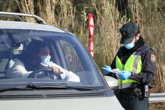 A police officer at La Jonquera making sure a French driver has proof of a negative PCR test (by Gemma Tubert)